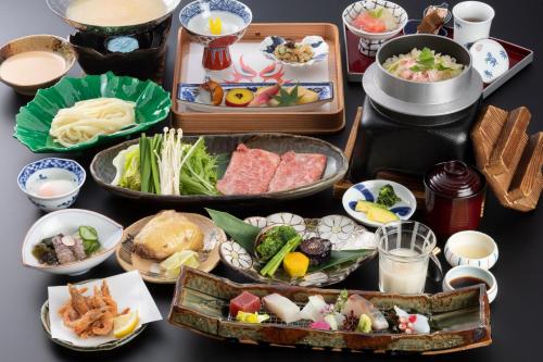 琴平町Onyado Shikishima-kan的一张桌子上放着几盘食物