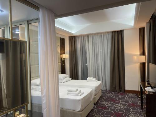 苏呼米Grand Hotel Sukhum Resorts的酒店客房,设有两张床和镜子