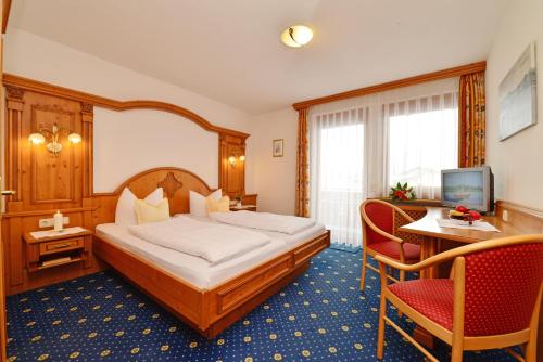 苏尔茨贝格Hotel-Pension Seebad "Seegenuss-Natur-Spa"的酒店客房带一张床、一张桌子和椅子