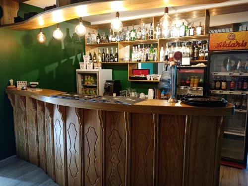 Līvāni伽玛酒店的一个带木柜台和绿色墙壁的酒吧