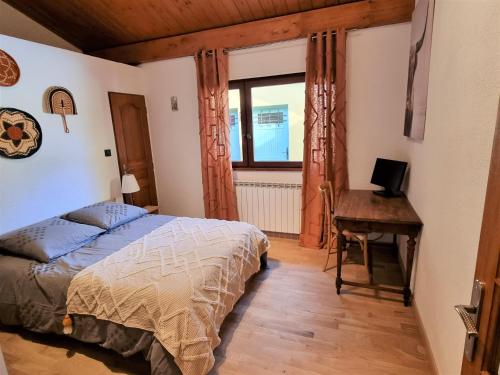 沙博尼耶尔莱班Le Chalet的一间卧室配有一张床、一张书桌和一个窗户。