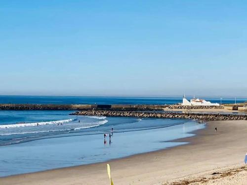 孔迪镇Alamedastudio的沙滩上的人在沙滩上和大海上散步