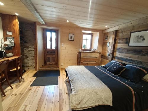 瓦什雷斯Atelier des Sapins Blancs (chambre double)的小木屋内的卧室,配有一张床和一张书桌