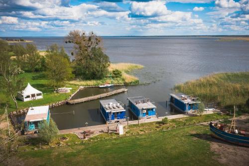 KarninHafenresort Karnin _ Hausboot Silv的享有湖泊的空中景致,设有房屋和船只