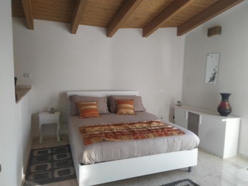 努奥罗Casa Ghirthalos的白色卧室配有带橙色枕头的床