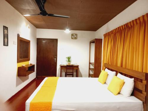 希克杜沃Coco Garden Villas 1的卧室配有一张带黄色枕头的大型白色床。