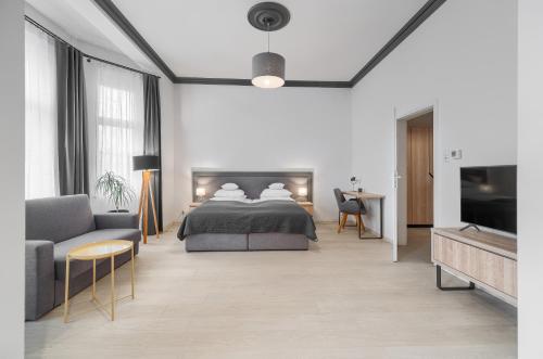 什切青Aparthotel Platinum的一间卧室配有一张床、一张沙发和一台电视。