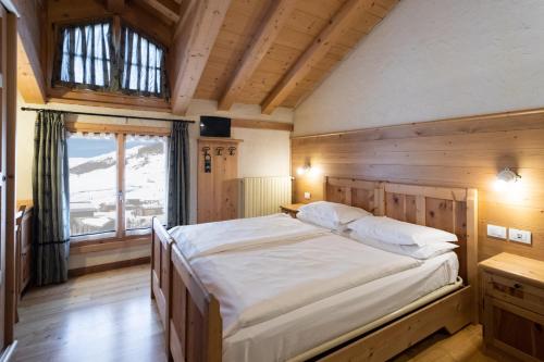 利维尼奥赫尔维蒂酒店的一间卧室设有一张大床和一个窗户。