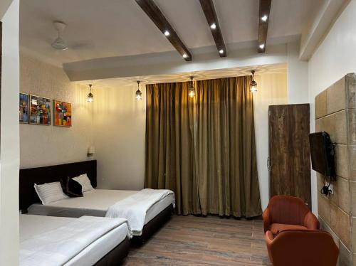 MadhupurThe Stoneberry Resort的酒店客房,配有两张床和椅子