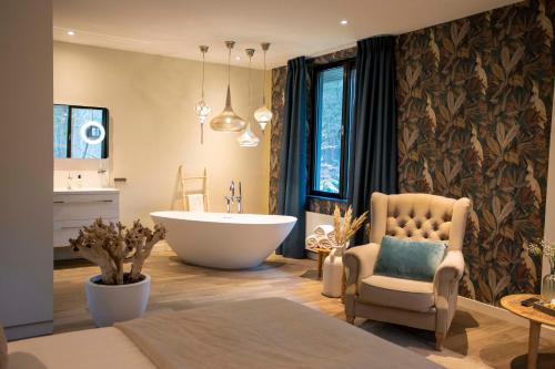 贝斯特Boutique Hotel Bed&Bos的带浴缸、椅子和水槽的浴室