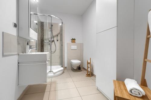 什切青Aparthotel Platinum的白色的浴室设有卫生间和水槽。