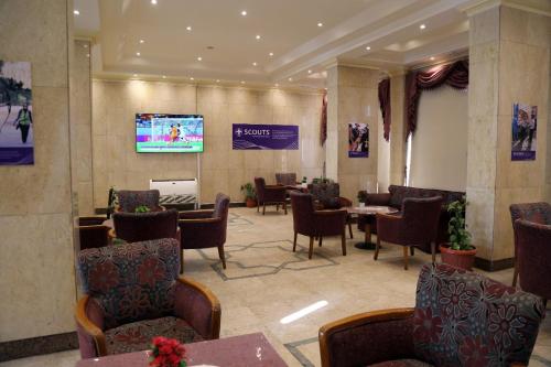开罗Cairo international Scout House的一间设有桌椅和电视的等候室