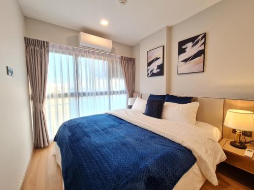 清迈Sky River Luxury Perfect For 5 People的一间卧室配有一张带蓝色毯子的床和窗户。