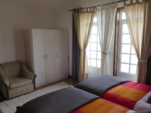 阿威罗阿威罗卢斯公寓的一间卧室配有一张床、一把椅子和窗户。