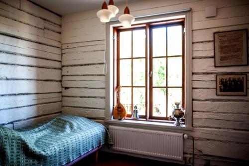科科拉Matkustajakoti Ykspihlaja的一间卧室配有一张床,窗户配有吉他
