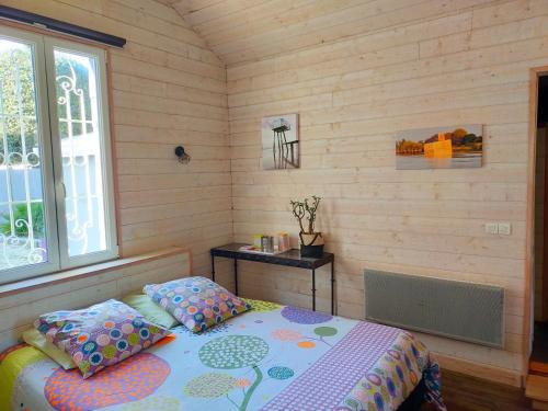 圣布莱温欧申Le Gage location de vacance à la semaine的一间卧室配有一张床、一张桌子和一个窗户。