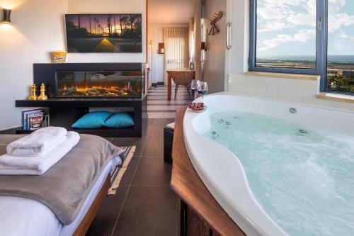 兹奇隆亚科夫Yama Wine Spa and Suites的一间带大浴缸和壁炉的浴室