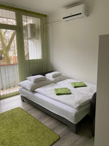 毛科Frézia Apartman的一间卧室配有一张带白色床单的床和一扇窗户。