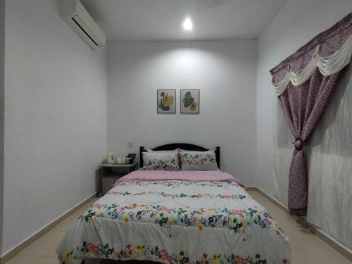 珍南海滩Dahliya Roomstay Langkawi的一间卧室配有一张带粉红色棉被的床