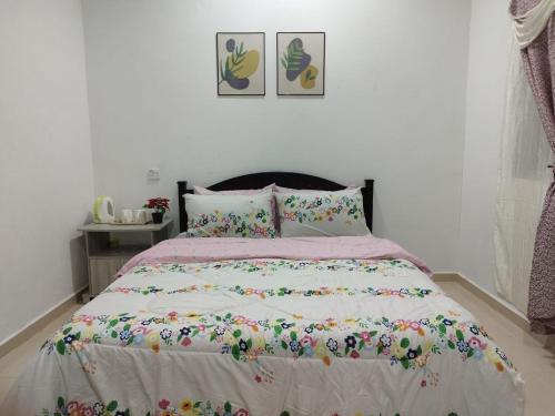 珍南海滩Dahliya Roomstay Langkawi的一间卧室配有一张带花卉床罩的床