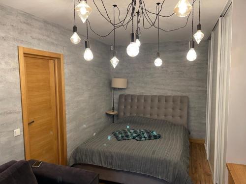 里加Modern Apartment suitable for longstays的一间卧室配有一张床和一个吊灯