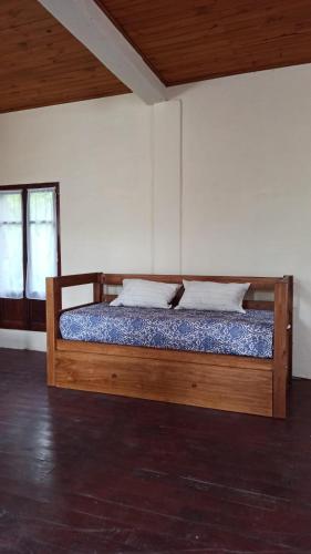 圣萨尔瓦多德朱Miraflores Casa de Campo的配有2扇窗户的客房内的木床