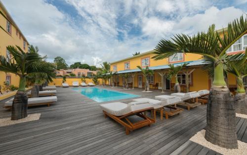 康隆尼角瓦纳一室公寓酒店的一个带游泳池、躺椅和棕榈树的度假村