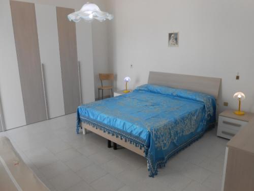 莱乌卡Casa Raffaele的一间卧室配有一张带蓝色棉被的床