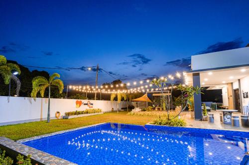 马六甲Good2Stay Villa的夜间在房子前面的游泳池