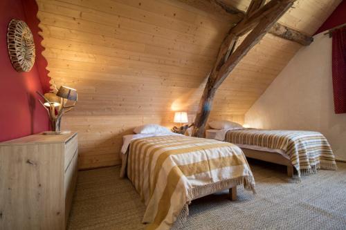 Le chant des pierres - douceur et nature的木制客房内的一间卧室配有两张床