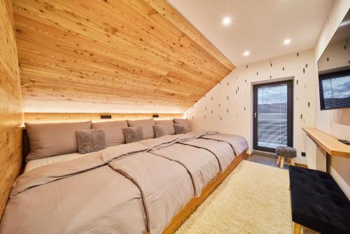 姆拉代布基B-arák wellness domek pod horama的一张位于带木制天花板的客房内的大床