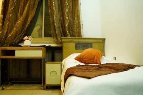 拉马拉ستوديوهات دانيال Daniel Studio的一间卧室配有一张床、一张桌子和一张四柱床。