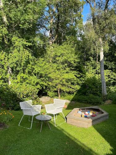 兰德维特Lantligt läge nära Göteborg och flygplatsen的院子里设有两把椅子和一张桌子,还有一个火坑