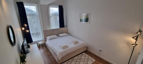 比斯特里察Apartament Calea Moldovei Residence - minibar si parcare GRATIS的一间白色的小卧室,配有床和2个窗户
