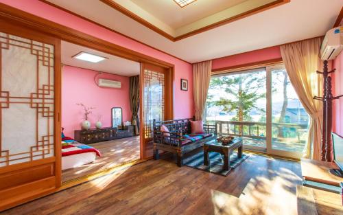 束草市卡萨西拉克住宿加早餐旅馆的一间设有粉红色墙壁和大窗户的客房