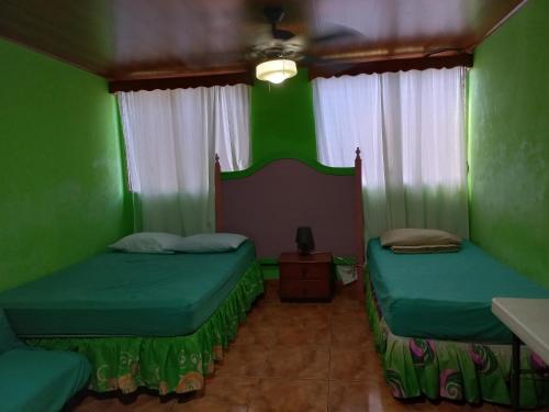 马那瓜Casa 114的绿墙客房内的两张床