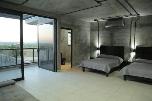 Casa en Allende con alberca (Casa Guaname)的一间卧室设有两张床和大窗户