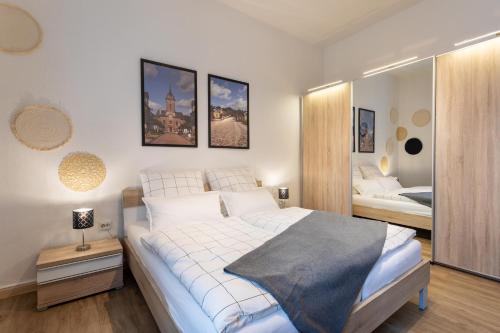 巴特阿罗尔森Apartment 54 - Ferienwohnung Bad Arolsen的卧室配有一张白色大床和镜子