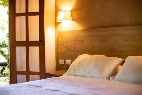 CalabazoPortales del Tayrona Garden Hotel的一间卧室配有一张带木制床头板和灯的床。