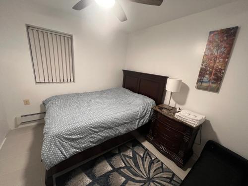 布鲁克林Lawn Residence的一间卧室,配有一张床和床头柜上的电话