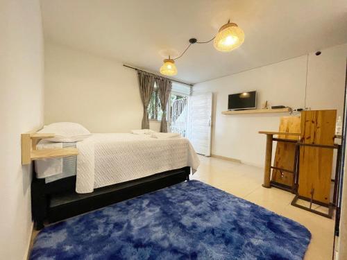 麦德林Selvática Alojamiento Eco的一间卧室配有一张床和蓝色地毯