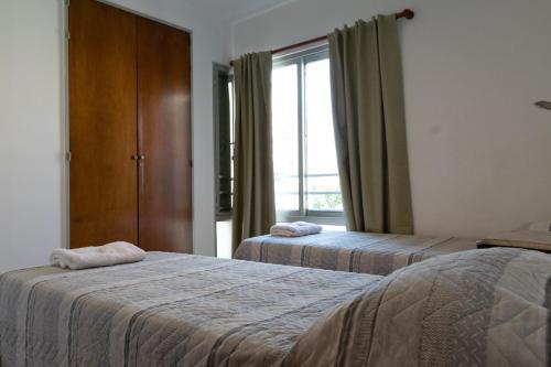 罗萨里奥Cómodo y Agradable Departamento Céntrico的酒店客房设有两张床和窗户。