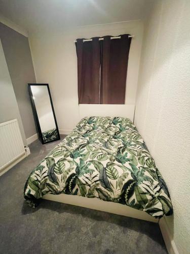 纽波特Shou’s guest house的一间卧室配有一张带被子和镜子的床