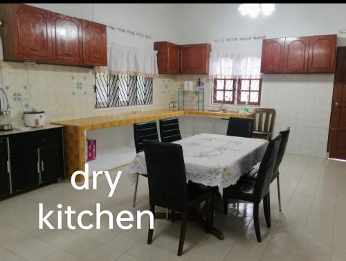 Kampong Parit TengahD'Aman Guesthouse Pontian的一间带桌椅的厨房和一间带厨房的厨房