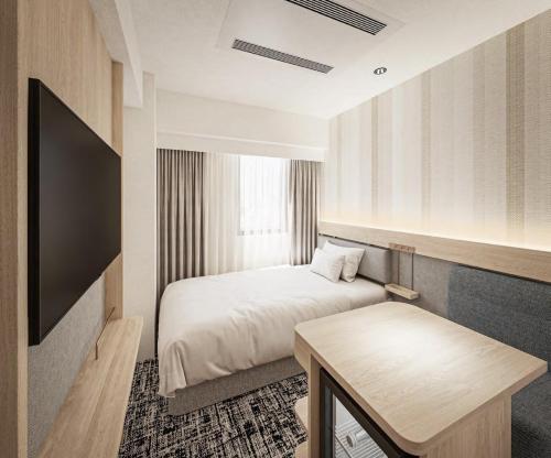 东京R&B HOTEL UENO HIROKOJI - Vacation STAY 13873v的酒店客房配有一张床铺和一张桌子。
