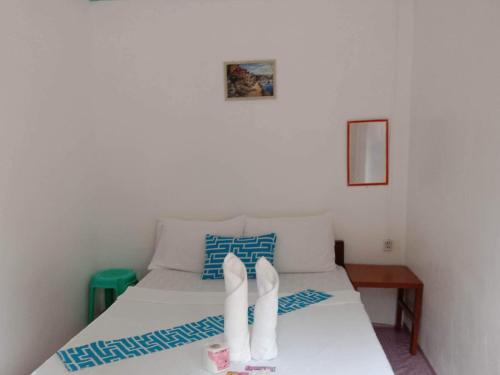 爱妮岛布卡纳海滨宾馆的一间卧室,床上有白色的鞋