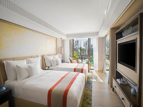 卡马拉海滩InterContinental Phuket Resort, an IHG Hotel的酒店客房设有两张床和一台平面电视。