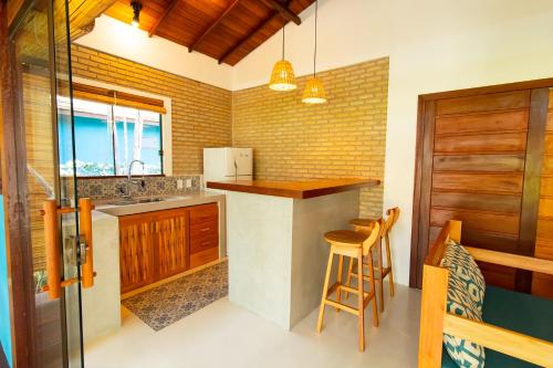 阿拉亚尔达茹达Vila Marina的厨房配有水槽和带椅子的柜台。