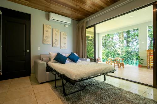 福尔图纳River Paradise Villa的一间卧室设有一张床和一个滑动玻璃门