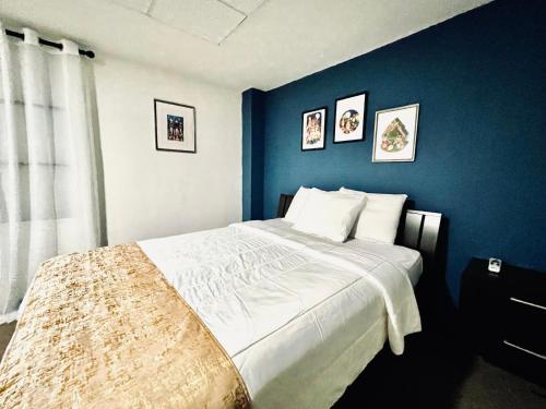 圣胡安SJ SUITES HOTEL的一间卧室设有一张蓝色墙壁的大床